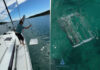 Wobbelstopper mechanical boat stabilizer being lowered beside a sailboat with the flap assembly shown underwater